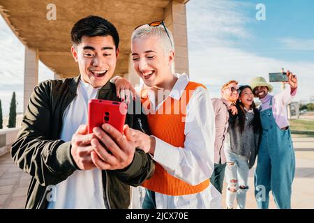 Couple or friends watching and having fun with a smart phone Stock Photo