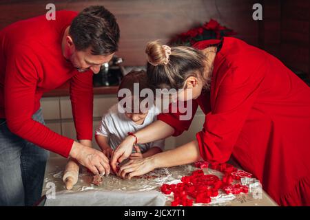 Homemade baking. Young family, father, mother and child, 4 year old boy Bake cookies. Happy Christmas moments. Cozy kitchen, happy home. Childhood. Stock Photo