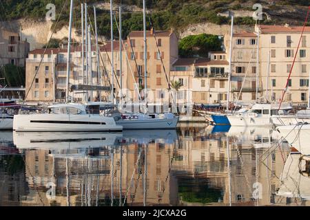 View across the harbour at sunrise, yachts reflected in tranquil water, Bonifacio, Corse-du-Sud, Corsica, France, Mediterranean, Europe