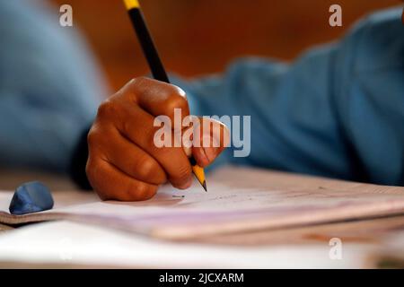 Primary school, boy in classroom, close-up on pencil, concept of education and school life, Kathmandu, Nepal, Asia Stock Photo