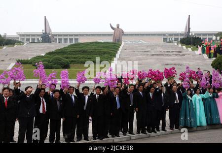 North Koreans waves pink and red plastic flowers as they welcome South Korea's President Roh Moo-hyun and North Korean leader Kim Jong-il in Pyongyang, the capital of North Korea, October 2, 2007. Stock Photo