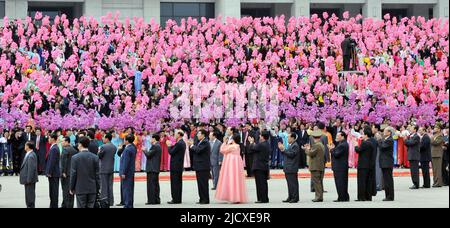 North Koreans waves pink and red plastic flowers as they welcome South Korea's President Roh Moo-hyun and North Korean leader Kim Jong-il in Pyongyang, the capital of North Korea, October 2, 2007. Stock Photo