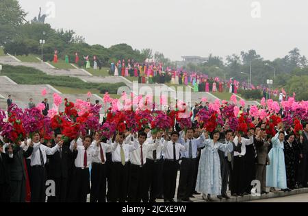 North Koreans waves pink and red plastic flowers as they welcome South Korea's President Roh Moo-hyun and North Korean leader Kim Jong-il in Pyongyang, the capital of North Korea, October 2, 2007. Stock Photo