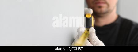 Male construction worker measuring size of wall with ruler closeup Stock Photo