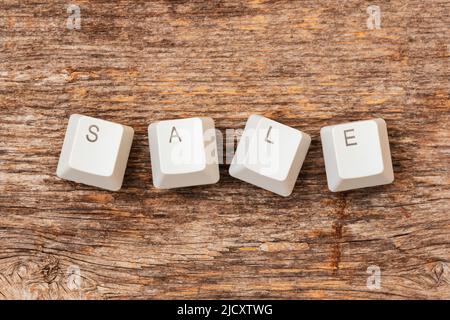 Computer keyboard keys arranged to spell SALE word on the wooden background. Online Sale. Stock Photo