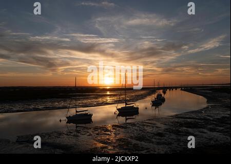 Sunrise with sailing boats moored on Mount lake  with  mudflats exposed with the low tide at Hurst spit. Milford on Sea, Hampshire, UK Stock Photo