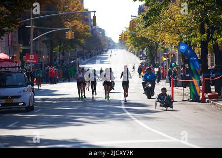 Brooklyn, New York,USA - November 3. 2019: women running at the NYC Marathon, wheelchair athlete on the right racing in Marathon Stock Photo