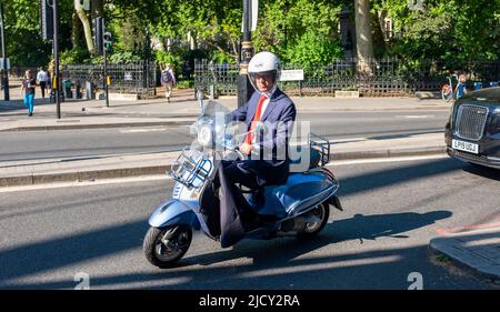 London UK 16th June 2022 - This commuter stays cool on his scooter near Westminster in London as the heatwave is set to continue over the next few days: Credit Simon Dack / Alamy Live News Stock Photo