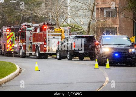 Police and emergency fire trucks on the street with lights on ligned up Stock Photo