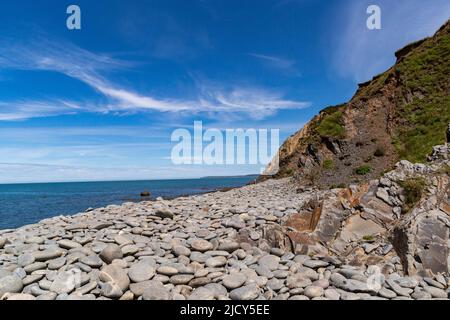 Scenic View of Greencliff Beach, With Pebbles, Crumbling Cliff and Coastal View Towards Croyde at Low Tide: Greencliff, Near Bideford Stock Photo