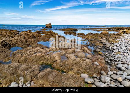 Colourful Sea View of Greencliff Beach, With Pebbles, Exposed Rocks and Coastal View Towards Lundy Island at Low Tide: Greencliff, Near Bideford Stock Photo