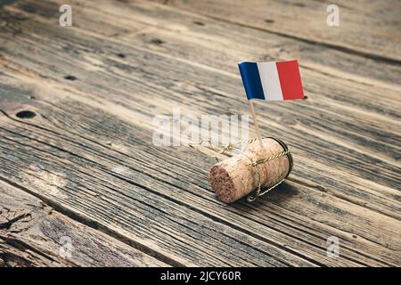 Champagne bottle cork with French flag on an old wooden table, Bastille Day and French National Day 14 July concept Stock Photo