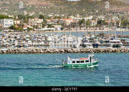 Aegina, Greece, - May 2022: Small passenger ferry leaving the town's harbour Stock Photo