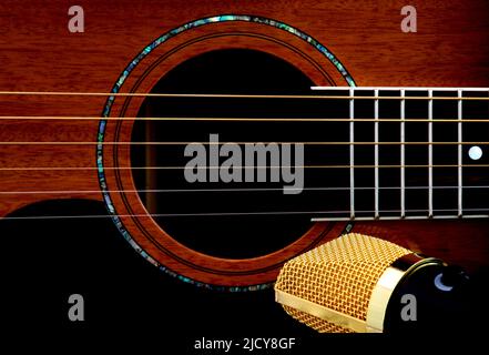 Closeup view of mahogany acoustic guitar and microphone Stock Photo