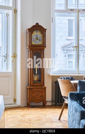 Vintage clock with a pendulum in the apartment  Stock Photo