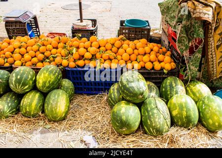 Fez, Morocco - June 16, 2022 Vegetables sold at the market in the medina of Fez during the coronavirus outbreak hitting Morocco, wearing a mask is man Stock Photo