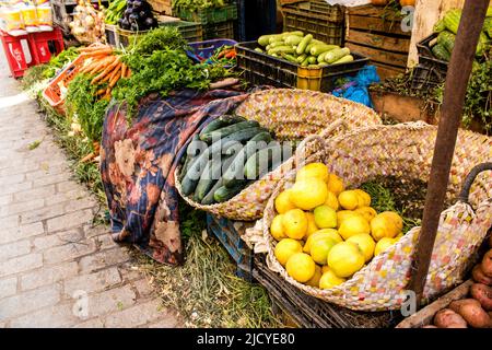 Fez, Morocco - June 16, 2022 Vegetables sold at the market in the medina of Fez during the coronavirus outbreak hitting Morocco, wearing a mask is man Stock Photo