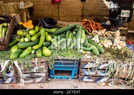 Fez, Morocco - June 16, 2022 Vegetables sold at the market in the medina of Fez during the coronavirus outbreak hitting Morocco, wearing a mask is man Stock Photo