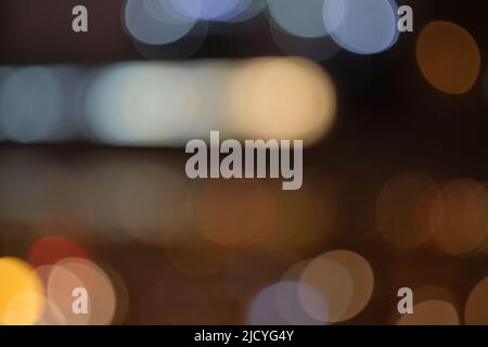 Artistic and dreamy bokeh of city lights at night.Taken with a manual vintage lens for a nostalgic aesthetic. Blurry for horizontal copy space. Stock Photo
