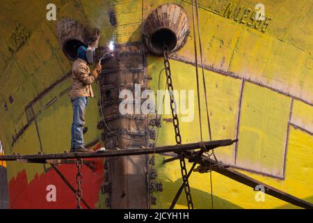 June 16, 2022, Dhaka, Dhaka, Bangladesh: Mechanics weld a ship at a dockyard in Keraniganj on the outskirts of Dhaka, Bangladesh. With dozens of shipyards, Keraniganj on the bank of the river Burigonga that flows past the southwest outskirts of Bangladesh capital Dhaka now seems a mega hub for building and repairing small vessels, launches and steamers. The area never sleeps with hundreds of workers dismantling the cargo ships and cruisers that are no longer in use to reuse their parts in new or repaired ones around the clock.There are more than 35 shipyards in Old DhakaÂ''s keraniganj area by Stock Photo