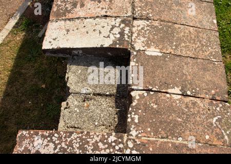 old brick work covered in lichen on top of a wall with missing and broken bricks Stock Photo