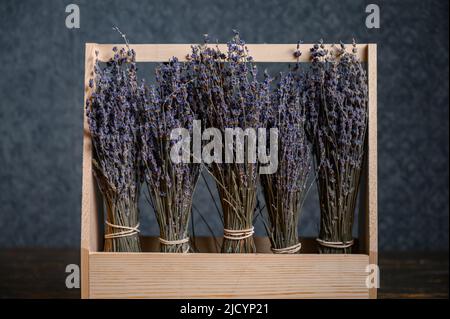 Composition of dried flowers in a wooden basket on dark background Stock Photo