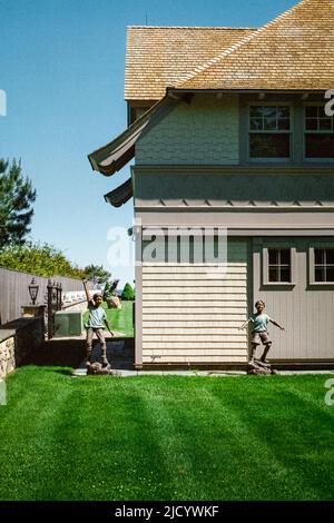 Lifesize status of children playing in a yard along side the road in North Hampton, New Hampshire USA. Stock Photo