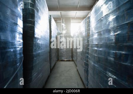 Cellophane wrapped toilet paper in paper recycling plant warehouse. Stock Photo