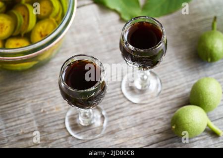 Homemade nut liqueur made from green unripe walnuts, close up Stock Photo