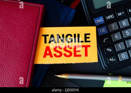 Tangible Asset text written on a notebook with pencils. Stock Photo