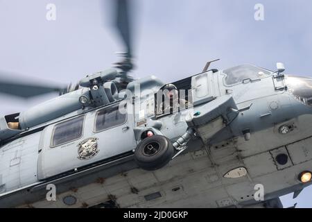 220607-N-HV010-1039 PACIFIC OCEAN (June 7, 2022) An MH-60S Sea Hawk, assigned to the “Black Jacks” of Helicopter Sea Combat Squadron (HSC) 21, conducts helicopter visit, board, search and seizure (HVBSS) training alongside U.S. Coast Guardsmen from Maritime Security Response Team West (MSRT-W) off the coast of San Diego.  During Helicopter Sea Combat Weapons School Pacific (HSCWSP) quarterly exercise PHOENIX TRIDENT ASSAULT, MSRT-W and squadrons from Helicopter Sea Combat Wing Pacific (HSCWP) and Helicopter Maritime Strike Wing Pacific (HSMWP) conducted HVBSS to board and secure vessels that w Stock Photo