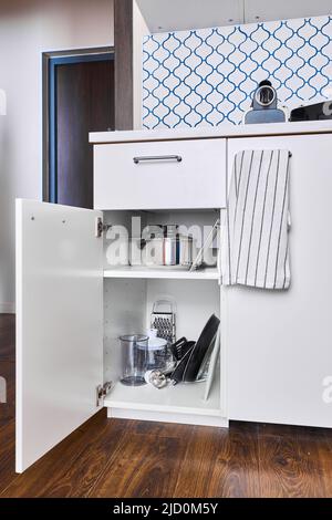 Photo of kitchen cabinet with pots and pans  Stock Photo