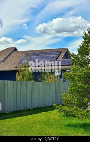 A row of solar panels placed on a house roof to gather the sun's light for energy to operate the house Stock Photo