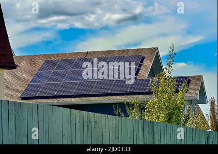 A row of solar panels placed on a house roof to gather the sun's light for energy to operate the house Stock Photo