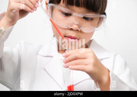 Little scientist. Smiling little girl learning classroom in school lab holding test tubes. Little girl playing science experiment for home schooling. Stock Photo