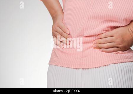 Back view of woman suffering from backache, waist pain, muscle or chronic nerve pain in her back after working. close up. Health problems, concepts of Stock Photo