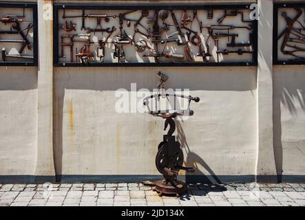 Metal chair made from metal garbage against the wall of the house Stock Photo