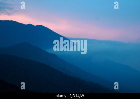 Early morning view of the slope of Mount Pangrango and lower adjacent hills in Mount Gede Pangrango National Park as seen from Cibulao, Tugu Utara, Cisarua, Bogor, Indonesia. Stock Photo