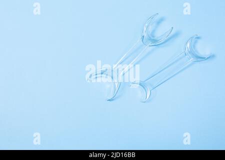 set of several Retractor Dental lip retractor Access to the oral cavity. Wide mouth opening for a dental procedure on a blue background Stock Photo