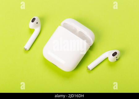 modern white wireless headphones on green background Stock Photo