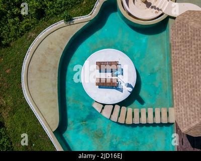 Aerial view of Naka Island near Phuket Thailand, a tropical Island in Thailand with beach chairs in the pool.  Stock Photo