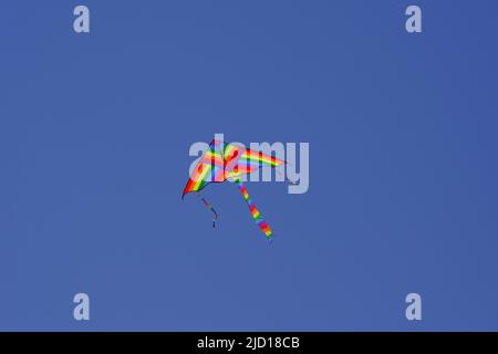 Huge colorful triangle kite at clear sky in a sunny summer day Stock Photo
