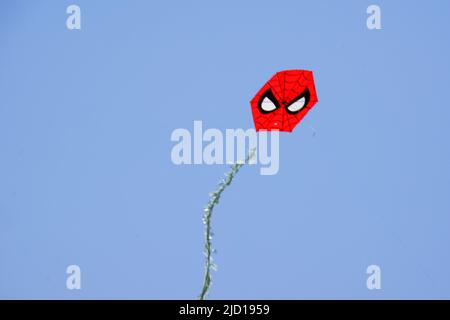 Spider man shaped red kite at clear sky in a sunny summer day Stock Photo