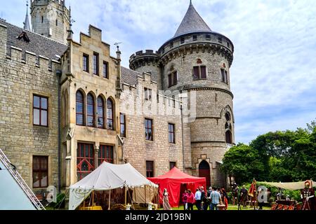 Pattensen, Germany, June 4, 2022: Market stalls of a historical Roman legion in front of the walls of a castle at a fantasy festival Stock Photo