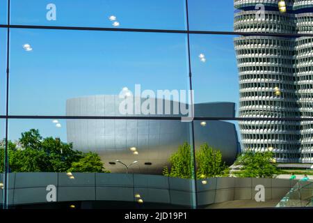 Reflections of the BMW Tower and BMW  Museum in the glass facade of BMW World Munich, Germany, 15.5.22 Stock Photo