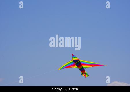 Huge colorful triangle kite at clear sky in a sunny summer day Stock Photo