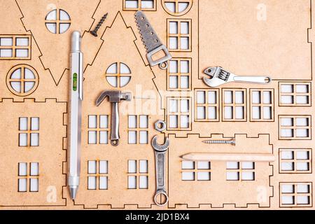 House building step by step. Construction background made from a flat home template and basic work tools. Stock Photo