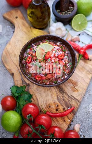 freshly made salsa dip sauce - chopped garlic, tomatoes and onion in wooden bowl Stock Photo