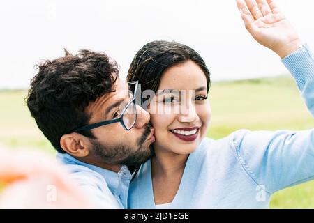 Selfie of a young couple kissing, Lifestyle of a cute couple taking a selfie, couple in love taking a selfie, concept of couples in love selfies Stock Photo