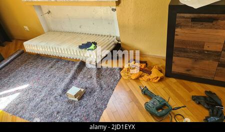 Dismantling a broken radiator in a private house. Radiator. Stock Photo